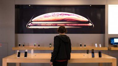 Bologna, İtalya - Ekim 2018: Apple Store'da yeni iphone X'lere ve Xs Max'e bakan müşteri.