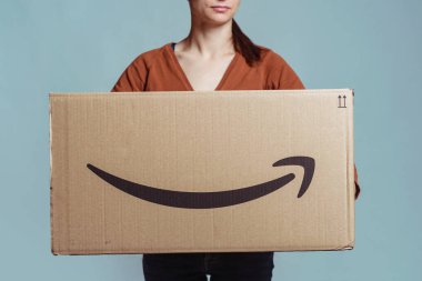 Bologna, İtalya - Aralık, 2018: Amazon'dan büyük karton kutu tutan kadın.