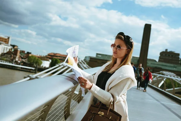 Retrato de mujer joven en Londres en el puente Millenium con mapa de la ciudad — Foto de Stock