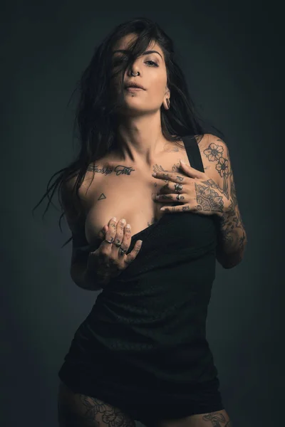 Sexy mujer estudio retrato con vestido negro y tatuajes contra — Foto de Stock