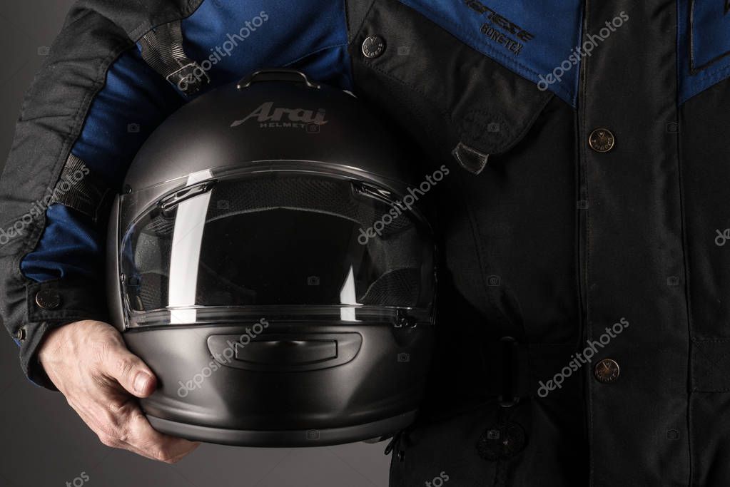 BOLOGNA, ITALY - JANUARY, 2019: Man holding Arai Helmet. Arai is a Japanese company that designs and manufactures motorcycle helmets and other helmets for motorsport, formed in 1926 by Hirotake Arai.