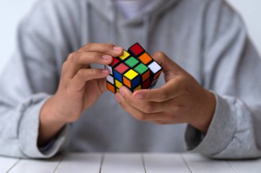 Bologna, İtalya - Nisan 2019: Rubik Küpü'nü çözen adam. Açıklayıcı başyazı. Problem çözme kavramı, çözüm, odaklanma ve hedef. 