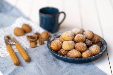 Fındık ve fincan ile beyaz ahşap masa üzerinde tabak hindistan cevizi bisküvi