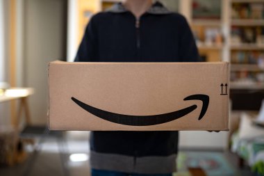 Pedaso, İtalya - Mayıs, 2019: Amazon'dan büyük karton kutu tutan çocuk.