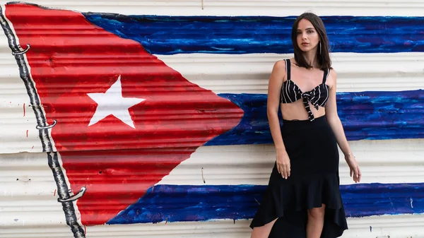 Портрет сексапильной женщины на фоне стены с кубинскими флагами — стоковое фото