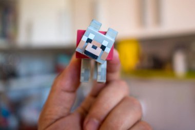 Bologna, İtalya - 5 Haziran 2018: Evde Minecraft oyuncak minifigure tutan genç çocuk. Minecraft oyun tasarımcısı Markus Persson tarafından oluşturulan bir video oyunu, daha iyi Notch olarak bilinir. Açıklayıcı editoryal.