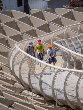 Sevilla, İspanya - Haziran 2018: Alman mimar Jurgen Mayer tarafından tasarlanan ve Nisan 2011'de tamamlanan Metropol Parasol'da yürüyen insanlar.