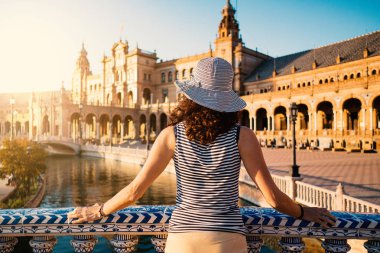 Woman admiring Plaza de Espana (Spain Square). Built on 1928, it is one example of the Regionalism Architecture mixing Renaissance and Moorish styles. Seville, Spain. Life style. clipart