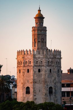 Sevilla, İspanya'da gün batımında Altın Kule (Torre del Oro). Guadalquivir nehri kıyısında yer alır ve XIII..