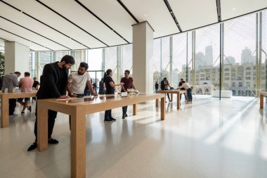Dubai - Ekim 2018: Apple Store içindeki yeni ürünlere bakan müşteri.