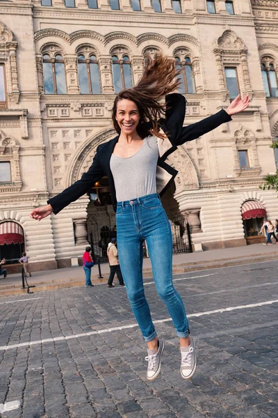 Счастливая улыбающаяся молодая женщина с портретом, прыгающая в Красную Скву — стоковое фото