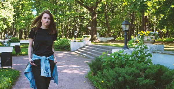 Jonge mooie vrouw portret wandelen buiten in het park in een — Stockfoto