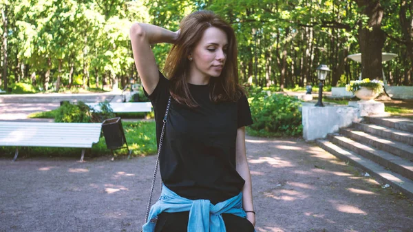 Young beautiful woman portrait walking outdoors in the park in a — Stock Photo, Image