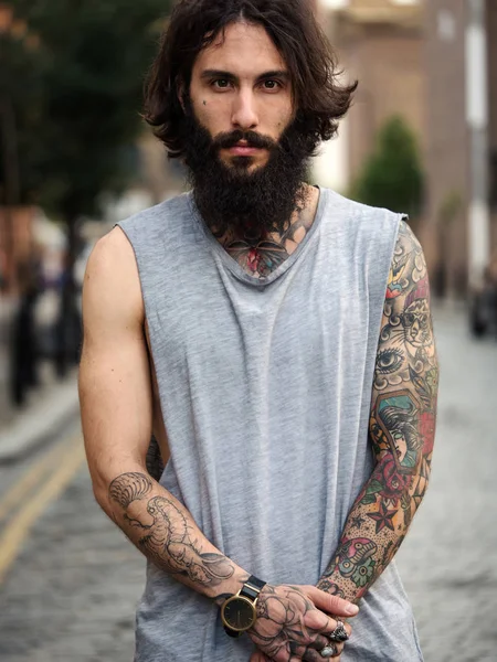 Intense portrait of young tattooed man on the street in Shoreditch borough. London, UK. Hipster style