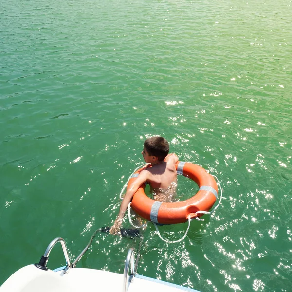 ラバローン湖でライフブイと一緒に泳いでいる若い子供 トレンティーノ アルト アディジェ州 イタリア フィルタリングされた写真のInstagramのスタイル ライフスタイルのイメージ 活動的な生活の概念 — ストック写真