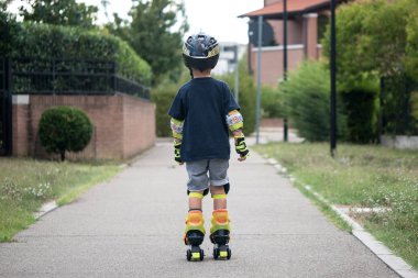 Yazın paten kayan genç bir çocuk dışarıda eğleniyor..