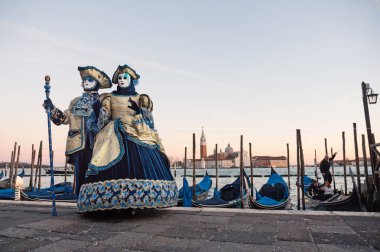 Sunset gökyüzü ile liman tarafından maskeler insanlar, Venedik Carnival, Italya