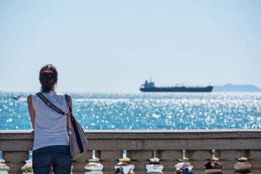Mascagni terasında denizin önünde dinlenen bir kadın. Livorno. Toskana, İtalya.
