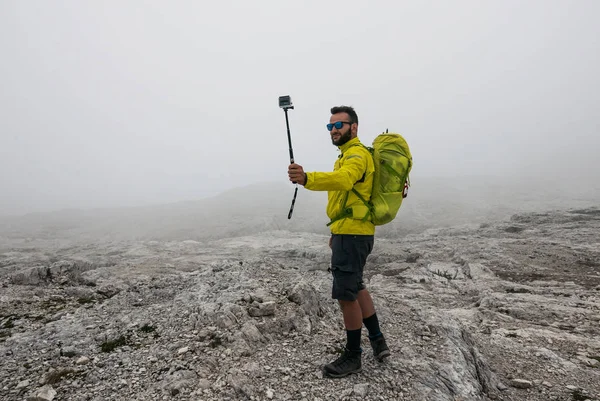 イタリアのドロマイト山で自撮りをするアクションカメラを使う男 — ストック写真