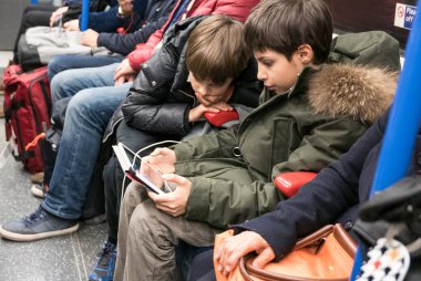 Küçük kardeşler seyahat ederken tablet kullanıyorlar.