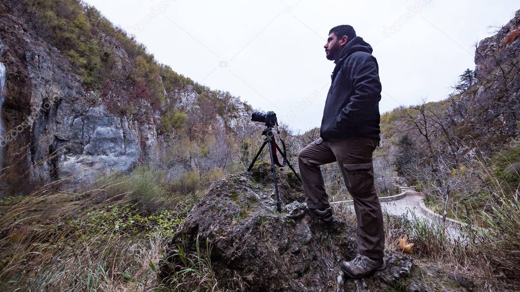 Professional photographer taking picture inside the Plitvice Lakes National Park. Croatia. Europe.