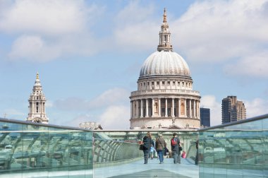 İnsanlar güneş ışığında Millennium köprüsü üzerinde yürüyüş, arka planda St Pauls katedral.