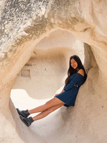 Young beautiful woman full body portrait inside rock formation in Cappadocia, Turkey.