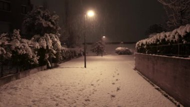 Gece sokakları, fener ışıkları ve parka düşen karlar.