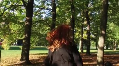 Güneşli parkta açık havada yürüyen genç kadın