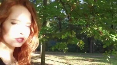 Güneşli parkta açık havada yürüyen genç kadın