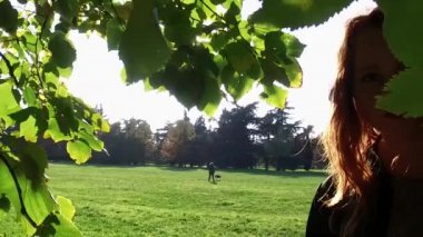 Güneşli parkta açık havada yürüyen genç kadın