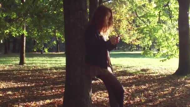 年轻女子在阳光明媚的公园户外散步 — 图库视频影像