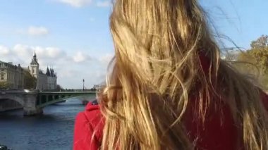 Sokaklarda yürüyen kırmızı ceketli portresi olan genç sarışın kadın