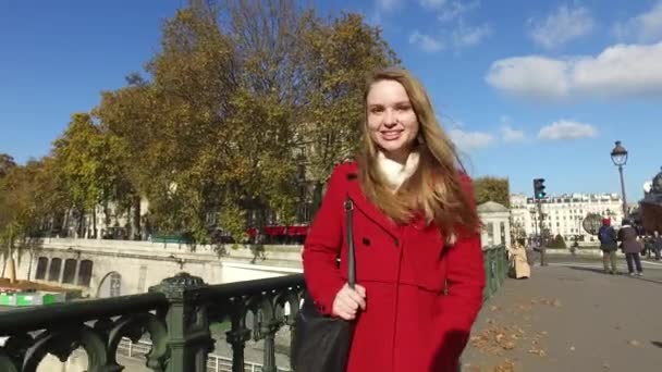 Mujer rubia joven con retrato de abrigo rojo caminando por las calles — Vídeo de stock