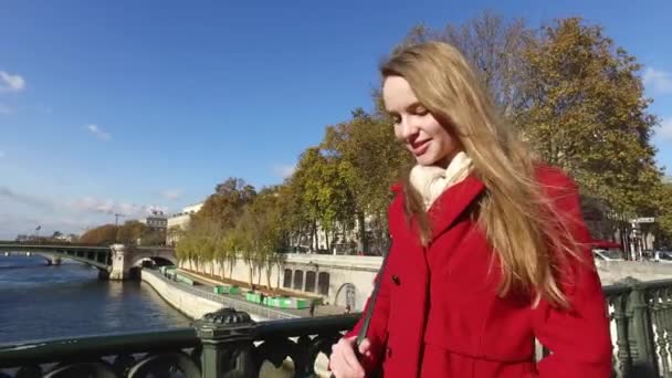 Sokaklarda yürüyen kırmızı ceketli portresi olan genç sarışın kadın — Stok video