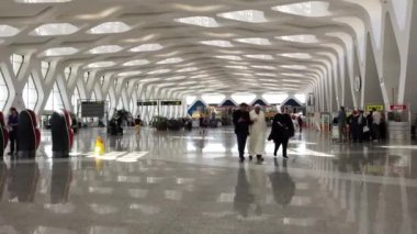 Marakeş, Fas - Nisan 2019: Menara Uluslararası Havaalanı iç görünümü nde turistler yürüyüş. Birlikte dikişli farklı fotoğraflar tarafından yapılan yüksek çözünürlüklü görüntü.