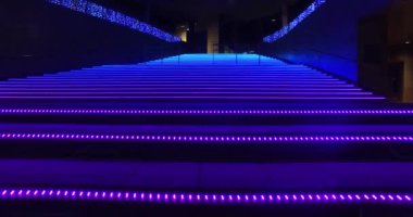 Renkli ışık saçan fütüristik merdivenlerde yürümek.