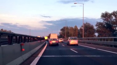 BOLOGNA, ITALY - CIRCA SEPTEMBER 2016: POV driving along tangenziale, the freeway around the city of Bologna at sunset.