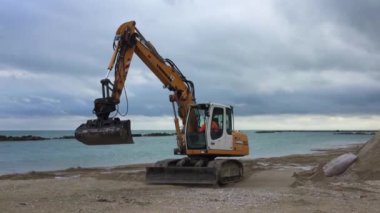 PEDASO, ITALY - OCTOBER 21, 2016: Escavator preparing the beach for winter time.