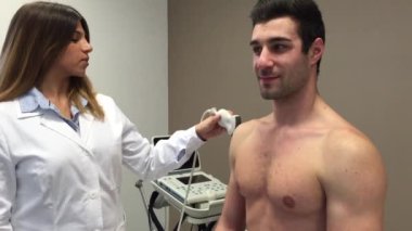 Kadın doktor tıp merkezinde ultrason ile erkek hasta ziyaret.
