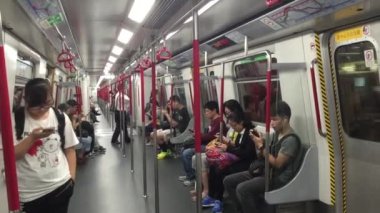 HONG KONG, CHINA - NOVEMBER 23, 2015: People using their smart phone while traveling inside MTR subway system. Lack of communication concept, problem of modern society.