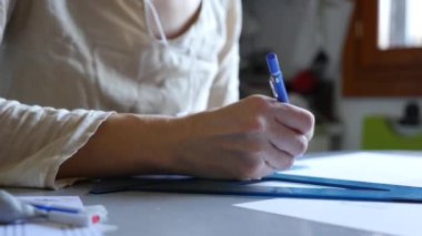 Woman technical drawing with set square and ruler at home.
