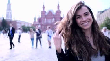 Young beautiful smiling woman relaxing outdoors on a sunny day in Moscow, Russia. Real lifestyle moment captured.