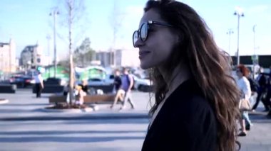 Young beautiful smiling woman relaxing outdoors on a sunny day in Moscow, Russia. Real lifestyle moment captured.