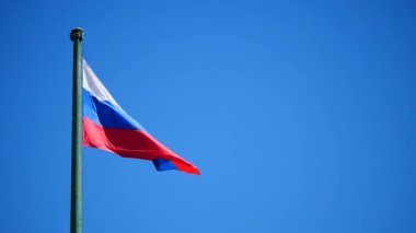 SLOW MOTION: Russian flag against blue sky background.