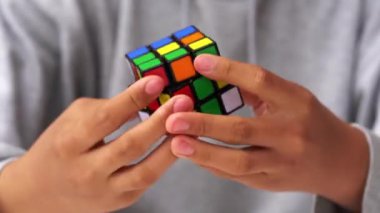 Bologna, İtalya - Nisan 2019: Rubik Küpü'nü çözen adam. Açıklayıcı başyazı. Problem çözme kavramı, çözüm, odaklanma ve hedef. 
