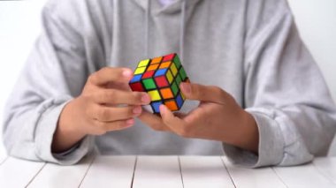 Bologna, İtalya - Nisan 2019: Rubik Küpü'nü çözen adam. Açıklayıcı başyazı. Problem çözme kavramı, çözüm, odaklanma ve hedef. 
