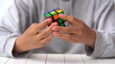 Bologna, İtalya - Nisan 2019: Rubik Küpü'nü çözen adam. Açıklayıcı başyazı. Problem çözme kavramı, çözüm, odaklanma ve hedef. 