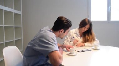 Doktor hemşirenin yanında tıbbi bilgi topluyor.