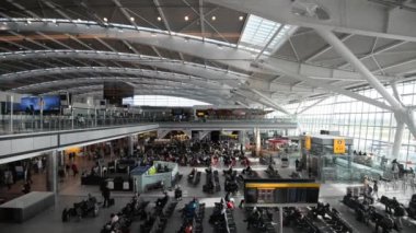 LONDON - 21 Mayıs 2015: Heathrow Havaalanı 'nın içinde yürüyen insanlar, Birleşik Krallık' ın en işlek havalimanı ve Avrupa 'nın en işlek havalimanı..